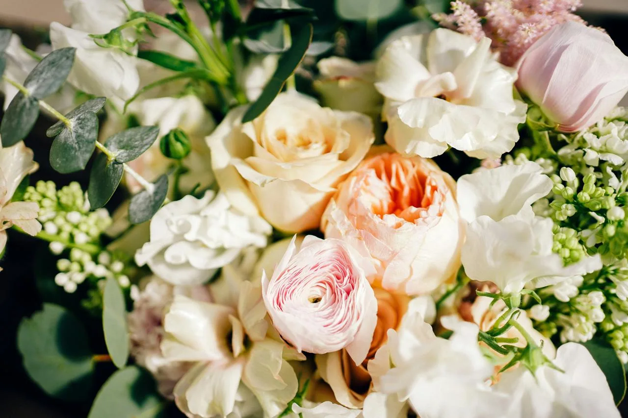 Close-up of a hand-tied bouquet in white and peach