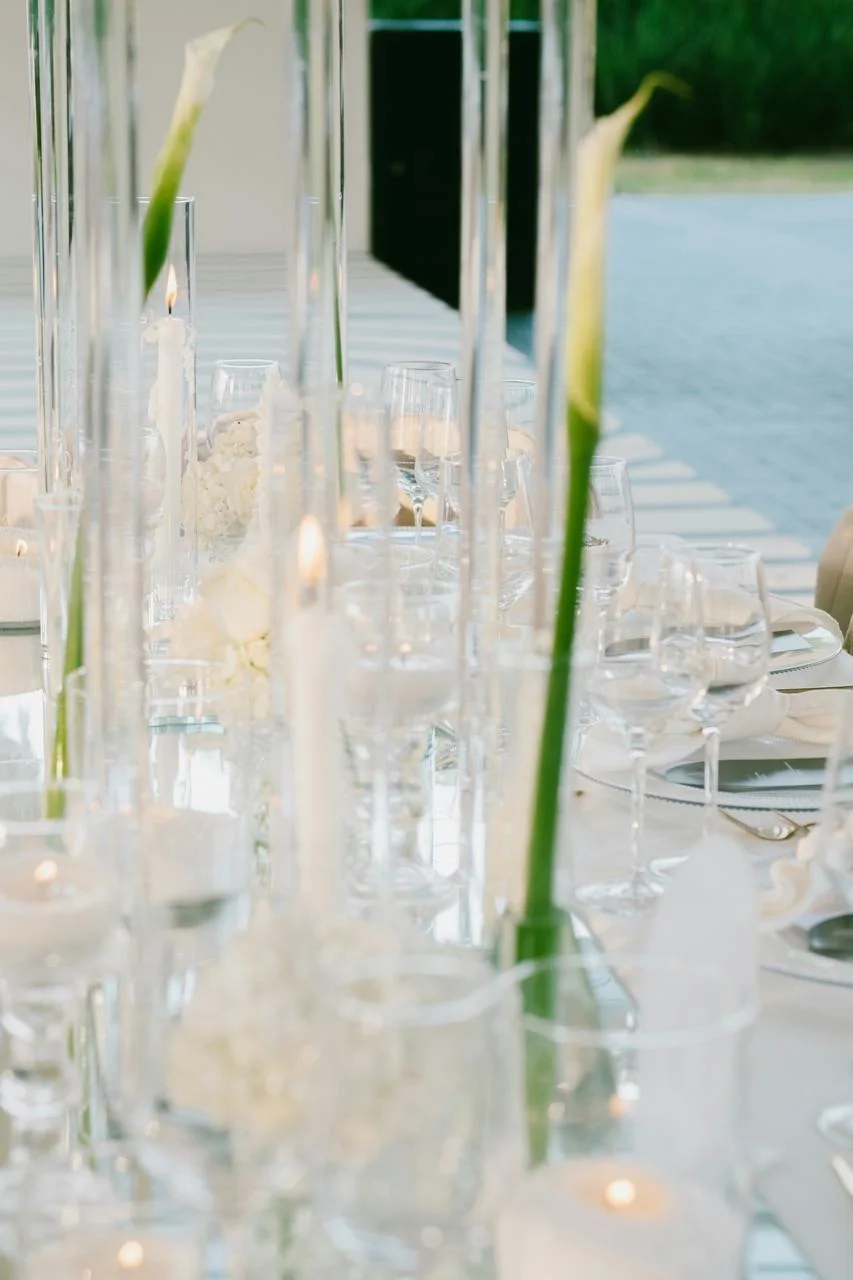 Calla lilies in tall glass vessels with candlelight