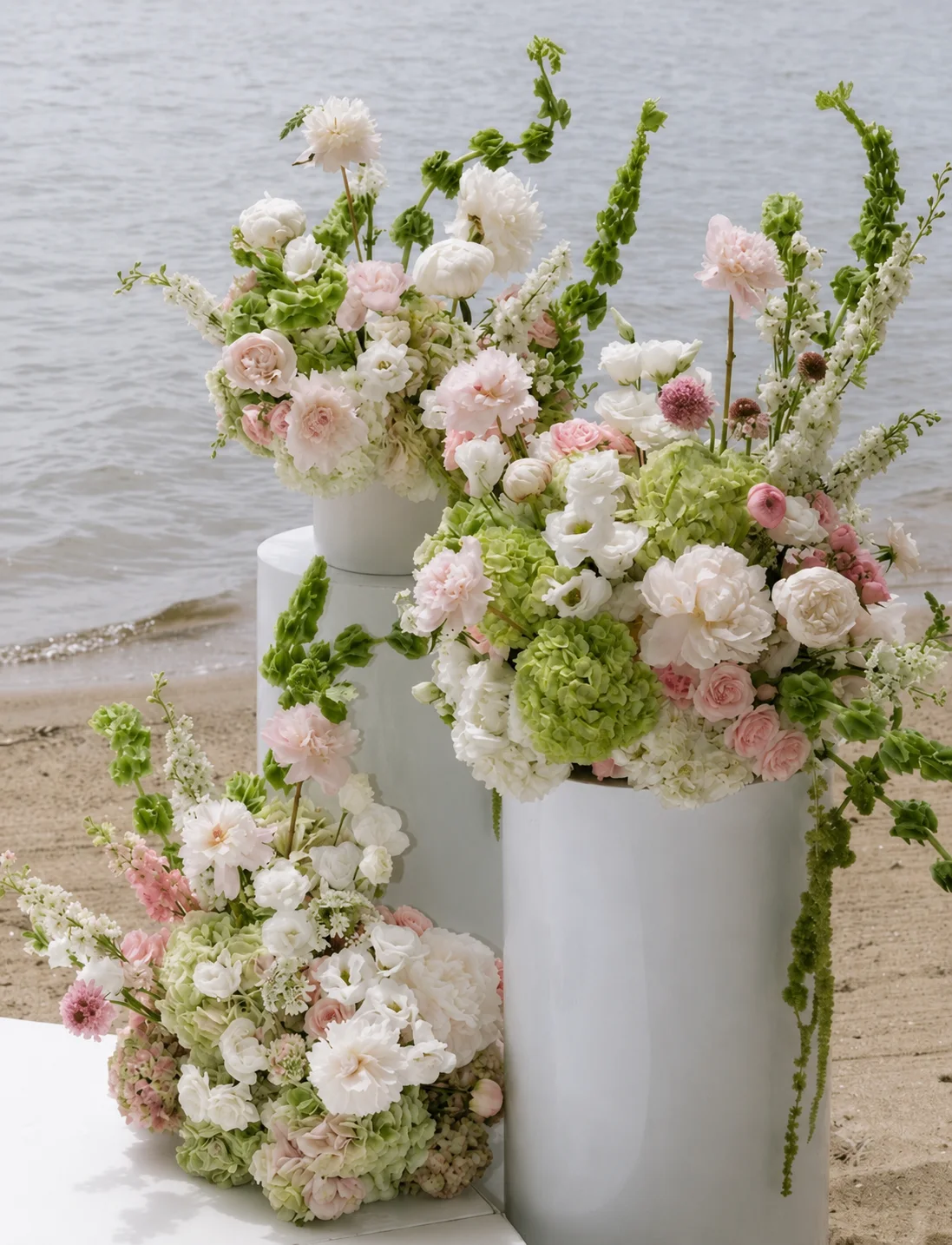 Waterside ceremony arrangements on white pedestals